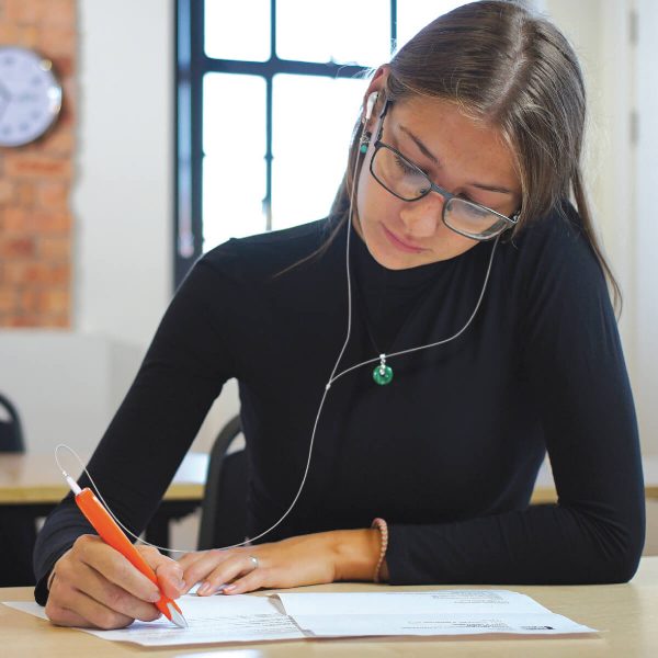 C-pen - studentessa che utilizza la penna collegata alle cuffie per "ascoltare" i testi cartacei